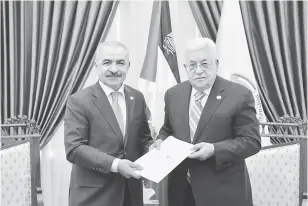  ?? — Gambar Reuters ?? AMBIL ALIH: Gambar serahan Pejabat Presiden Palestin ( PPO) pada Ahad menunjukka­n Shtayyeh (kiri) menerima surat pelantikan daripada Abbas untuk membentuk kerajaan baharu Palestin, di Ramallah, Tebing Barat pada Ahad.