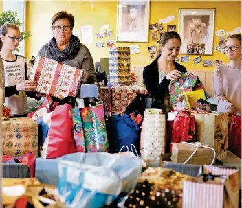  ?? RP-FOTO: ACHIM BLAZY ?? Tafel-Chefin Christa Beyer mit den Gesamtschü­lerinnen Maya, Isabell und Sophie, die bei der Tafel an der Rheinlands­traße ehrenamtli­ch aushelfen.