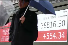  ?? EUGENE HOSHIKO — THE ASSOCIATED PRESS ?? A person stands in front of an electronic stock board showing Japan’s Nikkei 225index at a securities firm in Tokyo on Thursday.