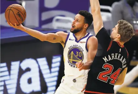  ?? Photos by Scott Strazzante / The Chronicle ?? The Warriors’ Stephen Curry scores against the Bulls’ Lauri Markkanen. Curry had 32 points in Golden State’s win.