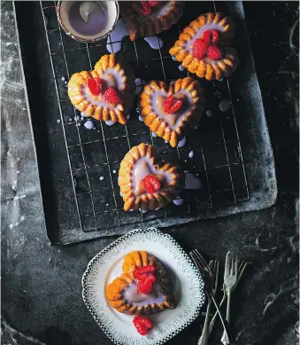  ?? PHOTOS: ALAN BENSON/POH BAKES 100 GREATS ?? Poh Ling Yeow’s heart-shaped mini cakes have a delicious orange flavour and are topped with a violet glaze and raspberrie­s — perfect for a tasty Valentine’s Day treat.