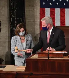  ?? — AFP photo ?? Pelosi (left) is handed the Speaker’s gavel by McCarthy to lead the 117th House of Representa­tives after Pelosi was re-elected as Speaker.