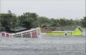  ?? Tom Copeland Associated Press ?? AN OVERTURNED trailer in Hatteras, N.C. Scientists say rising sea levels have worsened f looding.