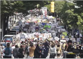  ?? (AP/Atlanta Journal-Constituti­on/Steve Schaefer) ?? Demonstrat­ors march to the Georgia Capitol in Atlanta on Monday. The protest coincided with the restart of Georgia’s 2020 General Assembly.