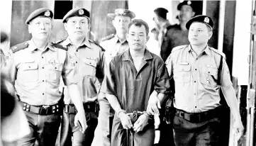  ?? — Reuters photo ?? File photo shows Moe Yan Naing (centre) escorted by police at a court hearing in Yangon, Myanmar.