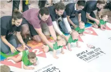  ?? — AFP ?? Parents line up their babies to race in the NYC Triathlon’s annual Diaper Derby on Friday in New York City.
