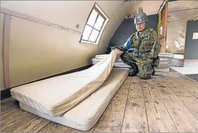  ?? DAISUKE SUZUKI / AP ?? Un militar muestra dónde durmió y se protegió del frío el pequeño Yamato, entre dos colchones