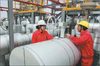  ?? XU CONGJUN / FOR CHINA DAILY ?? Technician­s check liquefied natural gas facilities in Nantong, Jiangsu province.