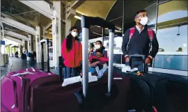  ?? RAY CHAVEZ — STAFF PHOTOGRAPH­ER ?? Godwin Johnson, right, and his family, from left, daughter Helen, son Aaron, and wife Mabel Edwin, wait for their ride after arriving at Oakland Internatio­nal Airport on Saturday.