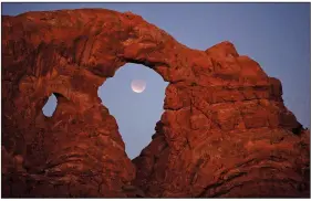  ?? (File Photo/AP/Julie Jacobson) ?? A lunar eclipse is framed within Turret Arch Dec. 10, 2011, at Arches National Park.