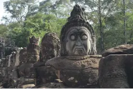  ??  ?? Staring contest: These statues form the sides of a bridge inside the Angkor Wat complex.