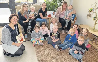  ??  ?? Mums Suzanne Murray, Kayleigh Campbell and Chelsea Wright, seated from left, with young book worms and artist Hazel Darwin-Clements.
