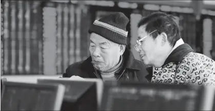  ?? AN XIN / FOR CHINA DAILY ?? Retail investors check share prices at a securities brokerage in Fuyang, East China’s Anhui province.