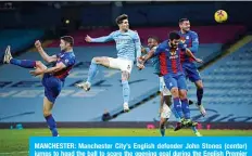 ?? —AFP ?? MANCHESTER: Manchester City’s English defender John Stones (center) jumps to head the ball to score the opening goal during the English Premier League football match between Manchester City and Crystal Palace at the Etihad Stadium in Manchester, north west England, on Sunday.