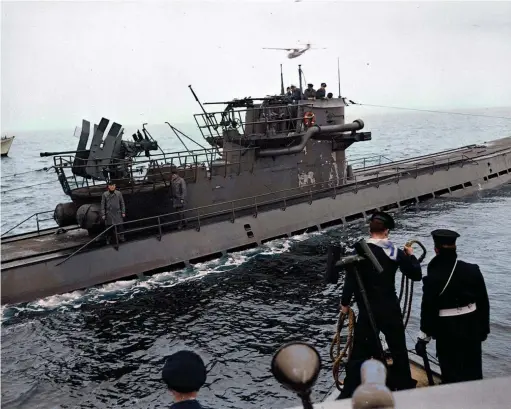  ?? (National Archives Canada) ?? ■ U-889 surrenders to a Canadian Fairmile (Q-117) off Shelburne, Nova Scotia, on 13 May 1945, as a Catalina circles watchfully overhead. Upon the surrender of Germany, the U-boat force were ordered to fly a black ensign on their vessels and to offer their surrender to Allied forces.