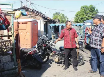  ?? ARI SETIYANING­RUM/JAWA POS ?? SOLUSI HARUS KONKRET: Ketua DPRD Kota Surabaya Armuji (kiri) saat sidak ke beberapa rumah di Jalan Ubi III, Kelurahan Jagir, yang berdiri di atas saluran air.