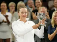  ?? AP ?? Iga Swiatek of Poland holds up the trophy after defeating Leonie Kung of Switzerlan­d 6-4, 6-2 in their girls’ singles final. —