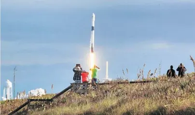  ?? PHOTOS BY JOE BURBANK/ORLANDO SENTINEL ?? Observers watch a Falcon 9 rocket lift off at Playalinda Beach, just north of Kennedy Space Center, on Thursday afternoon.