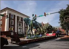  ?? Win Mcnamee / Getty Images ?? A flatbed truck carries a statue of Confederat­e General Robert E. Lee a park Saturday in Charlottes­ville, Va.