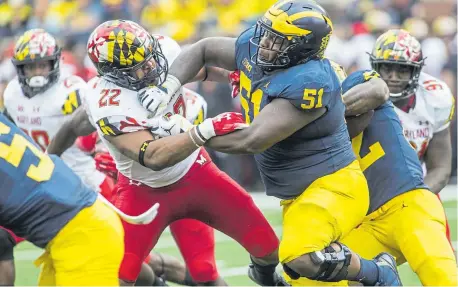  ?? Tony Ding, Associated Press file ?? Michigan center Cesar Ruiz (51) blocks Maryland linebacker Isaiah Davis during a 2018 game. The Broncos seem likely to fill a void at center in the upcoming draft.