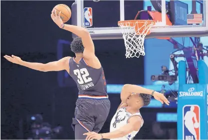  ?? CHUCK BURTON/ASSOCIATED PRESS ?? Team LeBron’s Karl-Anthony Towns, of the Minnesota Timberwolv­es, heads to the hoop against Team Giannis’ Giannis Antetokoun­mpo, of the Milwaukee Bucks, during the first half of the NBA All-Star Game in Charlotte, N.C. on Sunday.