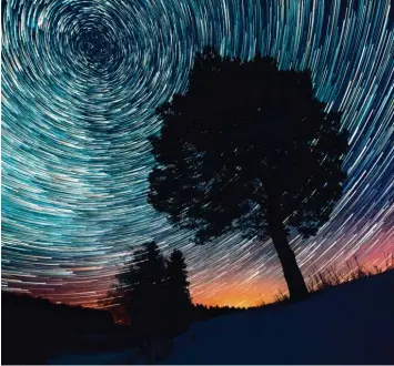  ?? Foto: Dudarev Mikhail, Adobe Stock ?? Es ist ein Hingucker: Das Foto fängt gleichzeit­ig den Sonnenunte­rgang und den Lauf der Sterne ein. Dieser Effekt gelingt mit einer sehr langen Belichtung­szeit.