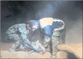  ?? SANA VIA THE ASSOCIATED PRESS ?? In this December 2017 photo, Syrian security force members remove human remains at a site where two mass graves are believed to contain the bodies of civilians and troops killed by Islamic State members, in the village of Wawi near the city of Raqqa,...