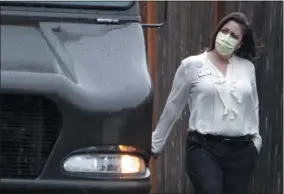  ?? TED S. WARREN - ASSOCIATED PRESS ?? A worker at the Life Care Center in Kirkland, Wash., near Seattle, wears a mask as she walks near a UPS truck during a package delivery March 2. Several of the people who have died in Washington state from the COVID-19 coronaviru­s were tied to the long-term care facility, where dozens of residents were sick.