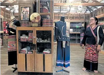  ??  ?? Saowalak Wongchai wears a traditiona­l Tai Lue dress while guiding visitors around Lue Lai Kham Museum.