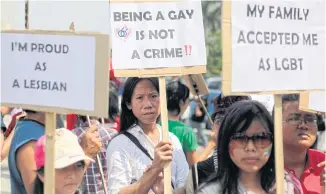  ??  ?? Indonesian activists hold posters during a protest demanding equality for LGBT people in Jakarta.