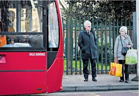  ??  ?? John Mcdonnell, the Labour shadow chancellor, waits for a bus as he heads for Parliament on Budget Day