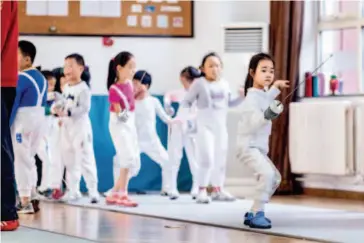  ??  ?? Seven-year- old Xiao Xiao practices fencing in a stadium. Although fencing is her own choice, Xiao Xiao is already telling her mom she has taken on too many classes. At the moment, Xiao Xiao is taking five different extra- curricular classes at the...