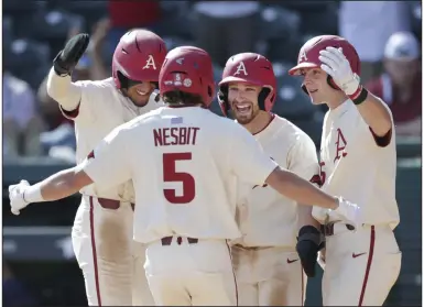  ?? (NWA Democrat-Gazette/Charlie Kaijo) ?? Teammates greet Jacob Nesbit after his three-run home run in the fourth inning helped No. 1 Arkansas to a 6-0 victory over Murray State on Sunday at Baum-Walker Stadium in Fayettevil­le. Nesbit’s homer helped the Razorbacks to their 10th win in a row to open the season. More photos at arkansason­line.com/38msuua/