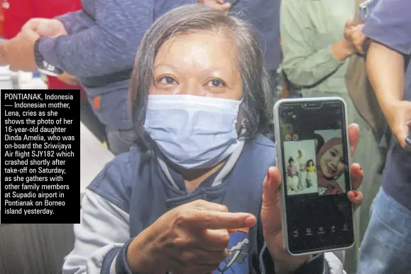  ??  ?? PONTIANAK, Indonesia — Indonesian mother, Lena, cries as she shows the photo of her 16-year-old daughter Dinda Amelia, who was on-board the Sriwijaya Air flight SJY182 which crashed shortly after take-off on Saturday, as she gathers with other family members at Supadio airport in Pontianak on Borneo island yesterday.