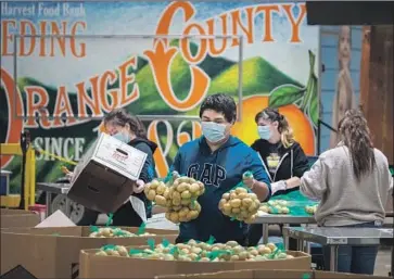  ?? Allen J. Schaben Los Angeles Times ?? WORKERS at Second Harvest Food Bank of Orange County pack boxes of food for low-income seniors in April. A federal policy waiver has expired, which means government food aid packages must include cheese.