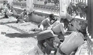  ?? OGM ?? Agentes de la Policía Nacional resguardad­os detrás de los muros del Palacio. Foto de 1966.