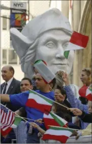  ?? HENNY RAY ABRAMS — THE ASSOCIATED PRESS FILE ?? Parade-goers wave Italian and American flags in front of a giant bust of Christophe­r Columbus as it rides on the Columbus Citizens Foundation float as part of Columbus Day Parade along Fifth Avenue in New York.