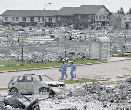  ?? JASON FRANSON/THE CANADIAN PRESS FILES ?? Workers put out markers around a devastated area of Fort McMurray last month.