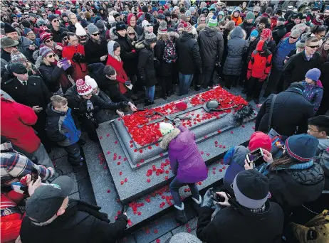  ?? JUSTIN TANG / THE CANADIAN PRESS ?? People lay poppies on the Tomb of the Unknown Soldier at the National War Memorial after Remembranc­e Day ceremonies in Ottawa on Sunday.