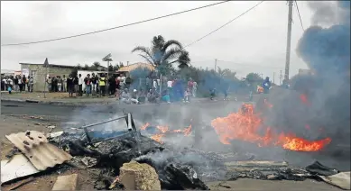  ?? Picture: BHONGO JACOB ?? STANDING FIRM: Protesters continue burning tyres in Nompumelel­o over land and a lack of electricit­y for shacks