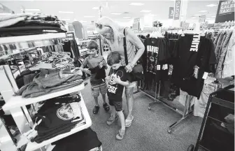  ?? Karen Warren / Staff photograph­er ?? Pam Parker shops with her grandsons Sam Weiss, 5, and James Weiss, 7, at Kohl’s in Meyerland. Many patrons said it was noticeably less crowded on Saturday.