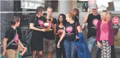  ??  ?? WEEK OF ACTION: StopAdani activists protesting at the GHD office in the Cairns Corporate Tower. Picture: ANNA ROGERS