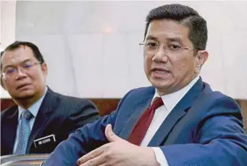  ?? PIC BY AHMAD IRHAM MOHD NOOR ?? Economic Affairs Minister Datuk Seri Azmin Ali (right) with Economic Planning Unit director-general Datuk Nik Azman Nik Abdul Majid in Putrajaya yesterday.