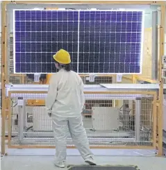  ?? REUTERS ?? A worker conducts quality-check of a solar module product at LONGi Green Technology Co Ltd’s factory in Xian.