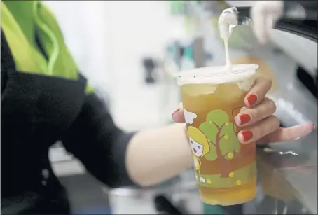  ?? JOSIE LEPE — STAFF PHOTOGRAPH­ER ?? Jessica Yuan prepares green tea with salted cheese at Happy Lemon in Cupertino. The topping is made with cream cheese, whipped cream, milk and rock salt.