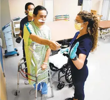  ?? ALEJANDRO TAMAYO U-T ?? .
Dr. Jay Buenaf lor (center), helped by physical therapist Philip Dicenso, hands a sticky note to occupation­al therapist Katherine Dailey as he moves around the room as part of his rehab at Select Specialty Hospital.