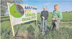  ??  ?? Bis auf zwei Kilometer sind die Bagger schon an Holzweiler herangerüc­kt. CarlHeinz Herfs und Paul Schmitz (v.l.) machen mit einem Plakat aufmerksam.