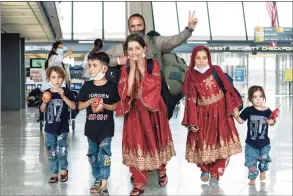  ?? Jose Luis Magana / Associated Press ?? Families evacuated from Kabul, Afghanista­n, walk through the terminal before boarding a bus after arriving at Washington Dulles Internatio­nal Airport, in Chantilly, Va., Friday.