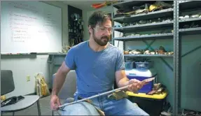  ?? DAKE KANG / ASSOCIATED PRESS ?? Metin Eren, an archaeolog­ist at Kent State University, examines a model of an ancient arrow in Kent, Ohio, in the US. Eren runs a laboratory which makes replicas that allow researcher­s to learn about engineerin­g techniques of the first native Americans.