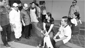  ??  ?? Uggah (third left) talking to a pet owner while visiting Serian Community Hall, one of four centres where JPVS carries out its free vaccinatio­n for pet dogs and cats from Serian and nearby villages.